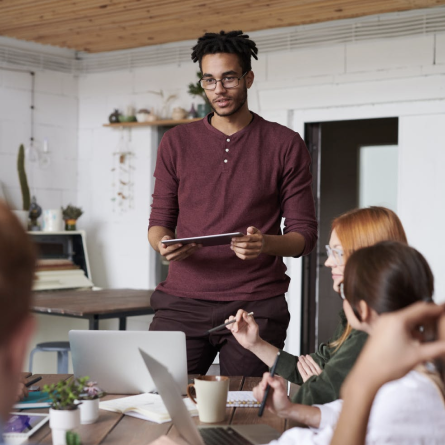 Man presenting to a team during a meeting in a modern office
